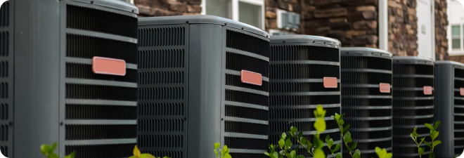 Row of HVAC units outside a building.